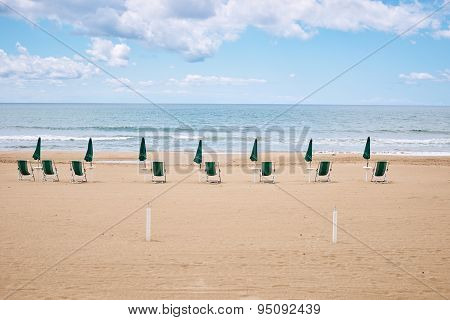 A beach with umbrellas and sun beds on coast