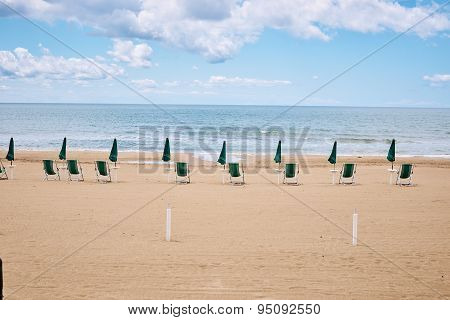 A beach with umbrellas and sun beds on coast