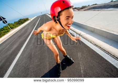 Woman in swimsuit with rollers on the highway