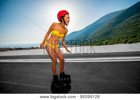 Woman in swimsuit with rollers on the highway