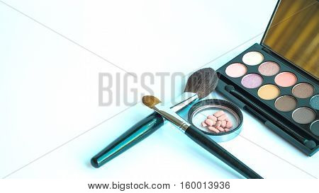 Makeup product on white blackground brown tone eye shadow make up with brush