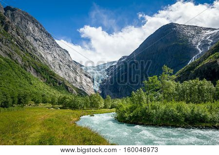 Mountain river from melted ice on the hiking path to Briksdalsbreen Glacier. Norway national travel routes.