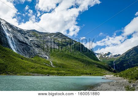 Melted ice lake landscape. Popular hiking path to Briksdalsbreen glacier. Norway.