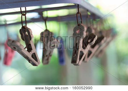Clothes pegs or clothespins hang on a cord. Plastic clothes pegs on a washing line.(selective focus)