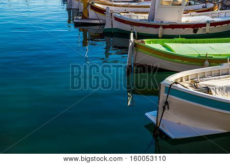 Mediterranean style owing boats in a glassy harbour