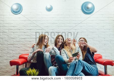 Beautiful girls sitting on the couch, have fun and make selfie Hostel