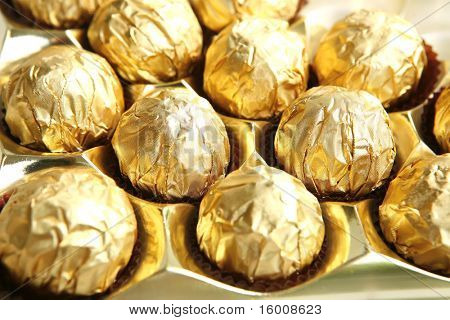 黄金の箔に白い背景の上のお菓子します。