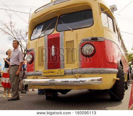 MOSCOW, RUSSIA - August 13, 2016: Guy and girl in clothes of the 1950's next to the retro city bus ZIS 155. Festive occasion of the Moscow bus on the Frunze Embankment. August 13, 2016 in Moscow, Russia