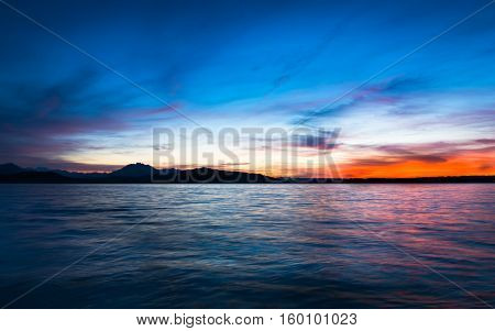 Dramatic sunset over the lake in the Swiss Alps. Canton Zug. In the background the mountains silhouettes. High Dynamic Range Image