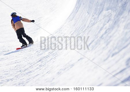 Snowboarder in halfpipe, focus on snow