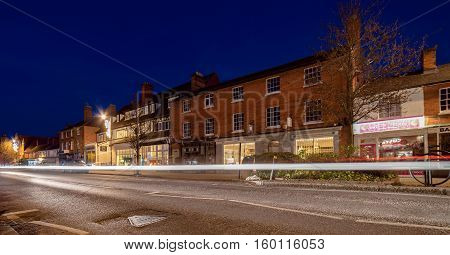Hartley Wintney, UK. 4th December 2016. Vehicles pass through the village of Hartley Wintney in Hampshire at twilight on a winter's evening.