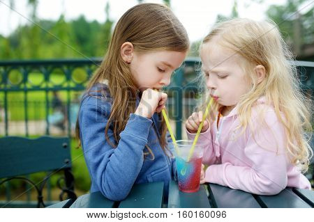 Two Cute Little Sisters Drinking Frozen Slushie Drink