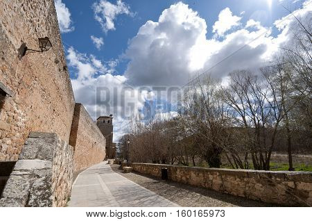 Ancient street next to San Cosme and San Damian Collegiate Church, Covarrubias, Burgos, Spain. It was built based on an earlier Romanesque church. It is a 15th century Gothic church. It has a Latin cross floor plan three naves and a crossing