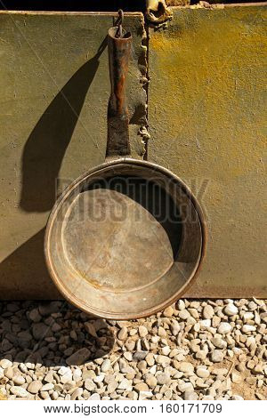 Selling old metal cookware in bazaar hanging over the ground