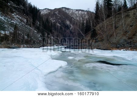 Mountain river and frosted trees with fog