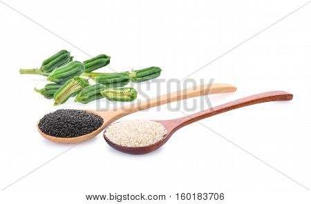 fresh sesame seeds pods with white and black sesame seeds in wooden spoon isolated on a white background