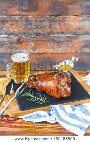 Roasted pork leg (rulka) served with garlic sauce and beer on the wooden table