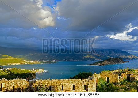 View to Budva Old town and bay from ruins of medieval fortress Tvrdava Mogren at the shore of Adriatic sea. Historic attractions of Budva, Montenegro