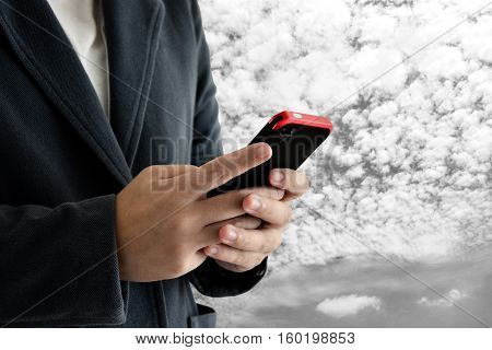 man wear suit and play smart phone with cloud background.