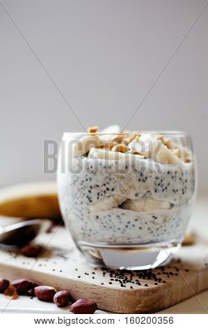 Banana chia yogurt pudding decorated with ripe sliced banana and peanuts
