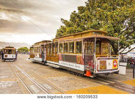 San Francisco CA USA October 23 2016: Powell Hyde cable car an iconic tourist attraction descending a steep hill peak overlooking Alcatraz prison island and the bay