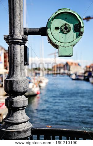 Bridge round metal detail attached to a public lighting pillar. It is isolated against background. Photo is taken in Copenhagen city center view on a canal. Sunny august day in Denmark