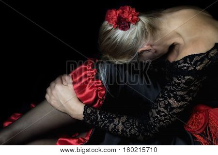 Low Key photo of resting middle age Flamenco Dancer. Women's figure fills most of the photos.