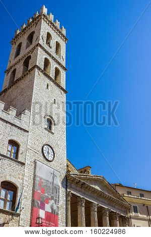 ASSISI ITALY - SEPTEMBER 4 2016: Palace of the People's Captain (Capitano del Popolo) Town Hall tower and the temple of Minerva on the Municipality Square (Piazza del Comune) in the old town of Assisi region of Umbria Italy