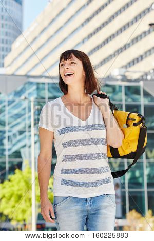 Happy Older Woman Carrying Duffel Bag Over Shoulder