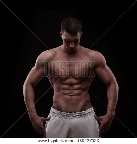 young athlete bodybuilder man isolated over black background