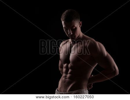 young athlete bodybuilder man isolated over black background
