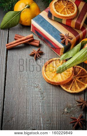 Christmas decoration with mandarines gifts cinnamon anise stars dried orange slices and spruce branches on a wooden background. Top view.
