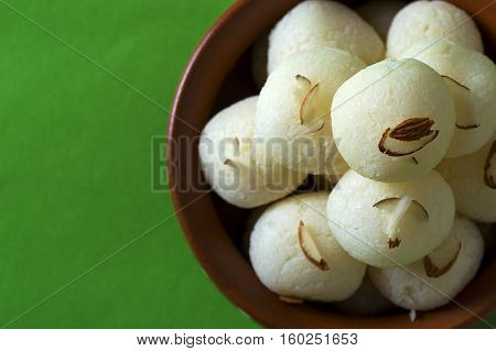 Indian Sweet or Dessert - Rasgulla, Famous Bengali sweet in clay bowl on green background
