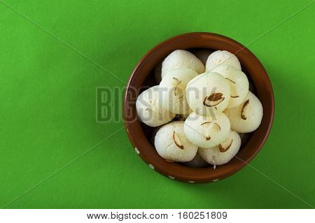 Indian Sweet or Dessert - Rasgulla, Famous Bengali sweet in clay bowl on green background