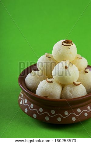 Indian Sweet or Dessert - Rasgulla, Famous Bengali sweet in clay bowl on green background
