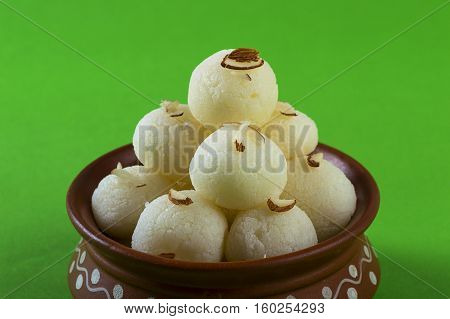 Indian Sweet or Dessert - Rasgulla, Famous Bengali sweet in clay bowl on green background