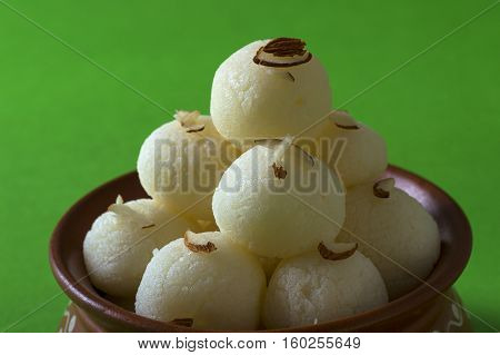 Indian Sweet or Dessert - Rasgulla, Famous Bengali sweet in clay bowl on green background