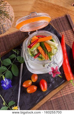 Dill pickle spears in open jar with sandwich ingredients