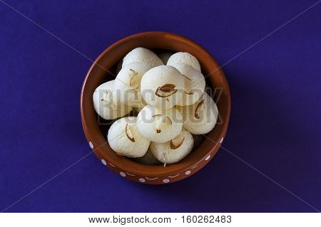 Indian Sweet or Dessert - Rasgulla, Famous Bengali sweet in clay bowl on blue background