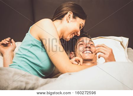 Couple kissing and having fun in bed