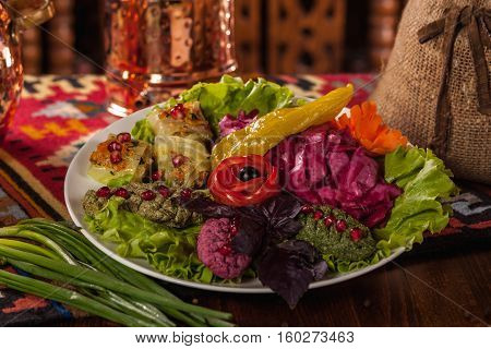 Georgian Cuisine. Dish Of Pickled Vegetables And Pkhali On A White Plate