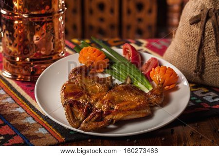 Chicken Tabaka With Carrots, Sliced Tomatoes And Green Onions On A White Plate
