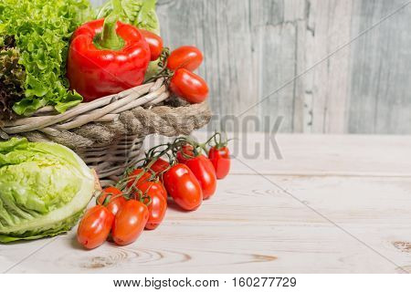Ingredients for fresh spring healthy green salad- green and red frech lettuce salad leaves paprika tomatoes - healthy low calorie food