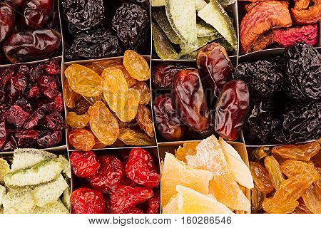 Assortment of dried fruits closeup background in square cells. Decorative pattern of dry exotic fruit. Top view.
