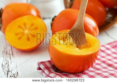 Japanese persimmon (Diospyros kaki) on white rustic wooden background
