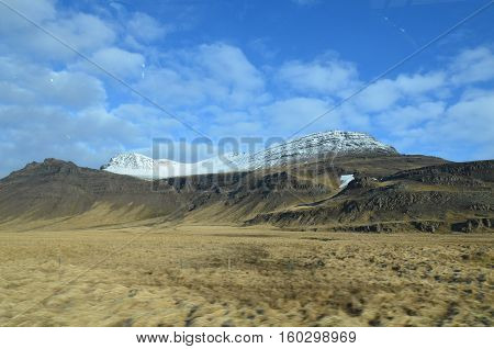 Gorgeous fluffy clouds hanging above the Rhyolite Mountains in Iceland.
