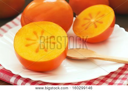 Japanese persimmon (Diospyros kaki) served on white plate
