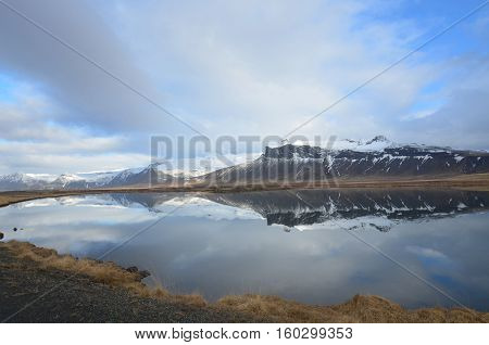 Water reflections of snow covered mountains in Iceland.