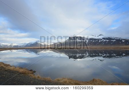 Lovely look at mountains reflecting in a large pool of water.