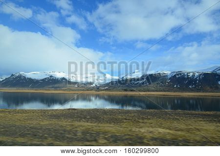 Snaefellsnes peninsula with snow covered mountains and reflecting pools.